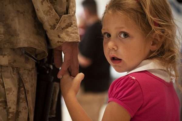 Soldier holding hands with his daughter