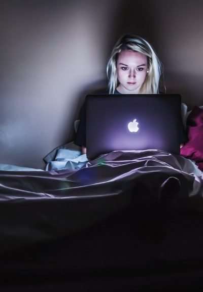 woman using computer in bed